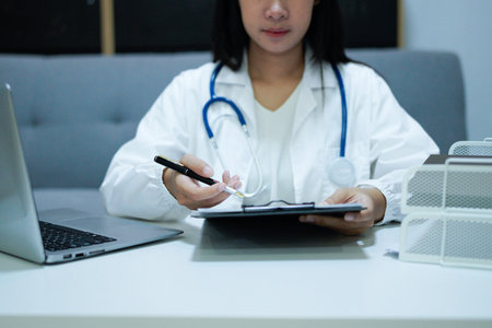 Healthcare professional doctor writing medical records on a clipboard. Female unrecognizable physician at work. Medicine and pharmacy.の写真素材