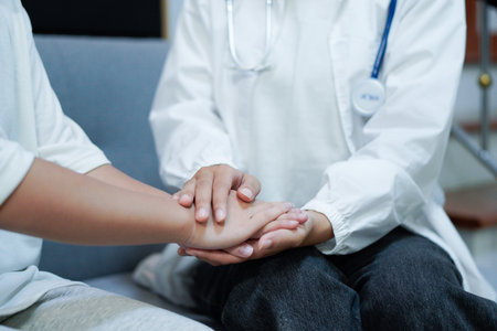 Hand of doctor reassuring her female patient. Medical ethics and trust concept.の写真素材