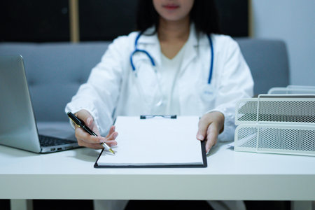 Female doctor recommends to fill in a medical document in the office..の写真素材