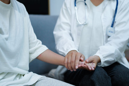 Hand of doctor reassuring her female patient. Medical ethics and trust concept.の写真素材
