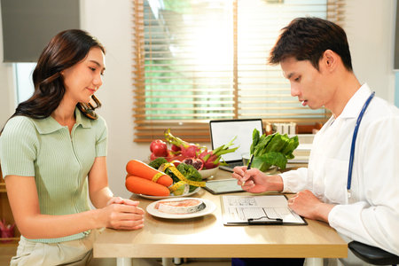Dietician, male nutrition specialist consulting woman, developing healthy diet, dietary program. Dietary consultant asking, giving male patient advice, help, nutritional information, new meal plan.の写真素材