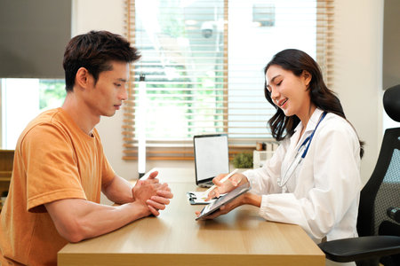 Female doctor explaining diagnosis to her patient during a medical consultation in a bright medical office, healthcare and medical concept. Medicine and health care concept.の写真素材