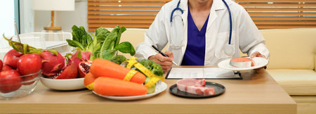 professional nutritionist in uniform writing notes on the table with different healthy products and drawings on the topic of healthy eating.の写真素材