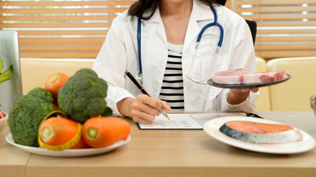 professional nutritionist in uniform writing notes on the table with different healthy products and drawings on the topic of healthy eating.の写真素材