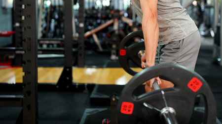 muscular body builder sport man is practice weight training on squat barbell for core muscle inside...