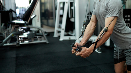 young man in the gym. a man is doing chest exercises using a cable machine in the gym. athlete...