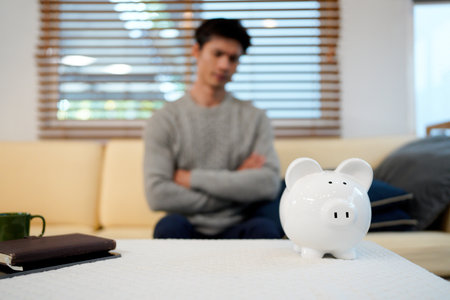 Stressed Man Managing Bills with Piggy Bank.の写真素材