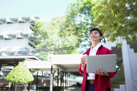 Man working remotely outdoors, drinking coffee and using laptop.