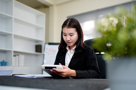 businesswoman using a calculator to calculate the numbers for financial document, finance accounting concept.の写真素材