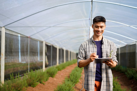 Farmer checking crops quality in greenhouse.