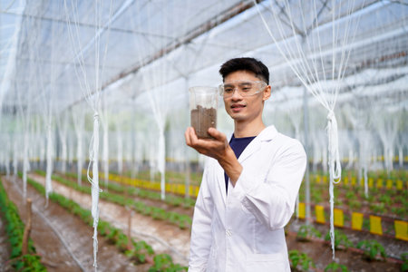 Researcher conducts soil analysis at a plant growth site to improve agricultural practices and...