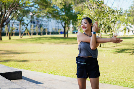 Healthy young Asian runner woman warm up the body stretching before exercise at park under warm light morning. Lifestyle fitness and active women exercise in urban city concept..の写真素材