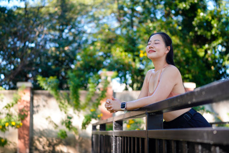 Portrait of beautiful young woman with closed eyes relaxing and breathing fresh air at outdoors park in the morning, Healthy wellness, Healthcare lifestyle, Life balance Concept.の写真素材