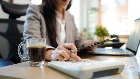 Finance planning, budget or savings manager calculating expenses, taxes or company profits with laptop, paperwork or calculator. female financial leader checking office staff payroll.の写真素材