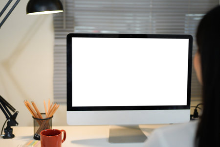 Rear view of businesswoman working with computer in modern office.