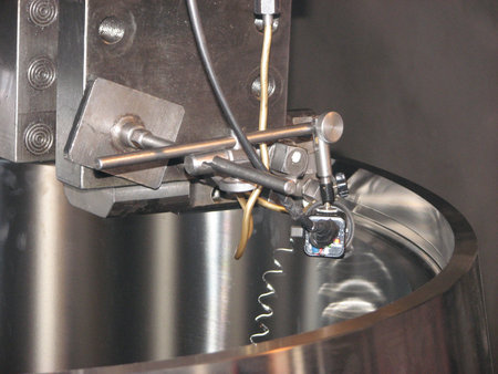 Close-up of precision industrial machinery with metal components, wires, and a sensor. Ideal for engineering, tech, or abstract backgrounds.の写真素材