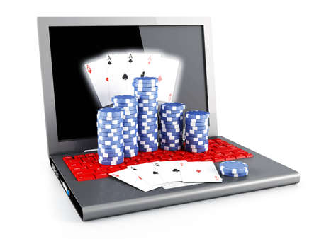 Gambling chips and poker cards on a laptopの写真素材