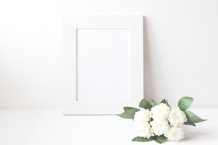 Picture frame with flower bouquet on wooden table.の写真素材