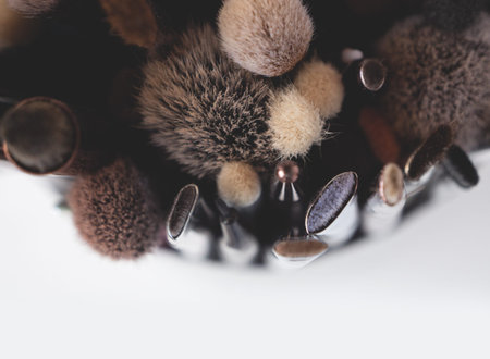 Close-up of professional dirty makeup brushes in tube on white background (color toned image,...