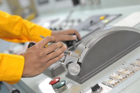 Shipping officer controlling shipping vessel at engine room の写真素材