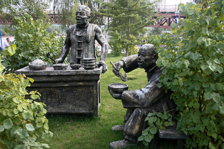 Statue of a man selling chinese food & a man eating there, Waterwheel Park Lanzhou\'のeditorial素材