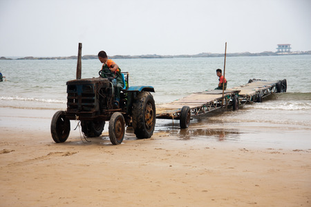 Workers working on the scenic spots of golden sand beachのeditorial素材