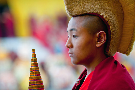 KATHMANDU, NEPAL - MARCH 25: Young Buddhist monk Karma, 9, carrying the Torma during Cham mystery at Shechen monastery on March 25, 2010 in Kathmandu, Nepal. Cham dances are considered a form of meditation and an offering to the gods.のeditorial素材