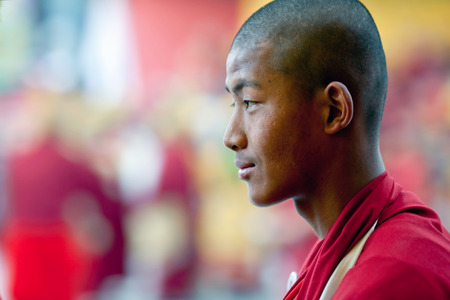 KATHMANDU, NEPAL - MARCH 25: Smiling Buddhist monk walking in a religious procession during Cham mystery at Shechen monastery on March 25, 2010 in Kathmandu, Nepal. Cham dances are considered a form of meditation and an offering to the gods.のeditorial素材