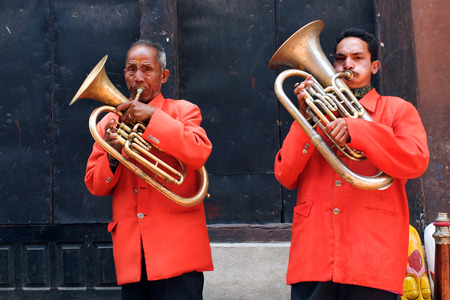 BHAKTAPUR, NEPAL - MAY 8: Nepalese musicians playing on brass trumpet on the street in Bhaktapur, Nepal, on May 8, 2008. Bhaktapur is located about 20 km east of Kathmandu.のeditorial素材