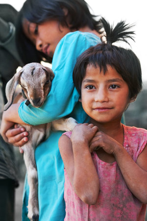 BHAKTAPUR, NEPAL - NOVEMBER 07: Nepalese girls with kid poses for a photo at local market on November 07, 2009 in Bhaktapur, Kathmandu valley, Nepalのeditorial素材