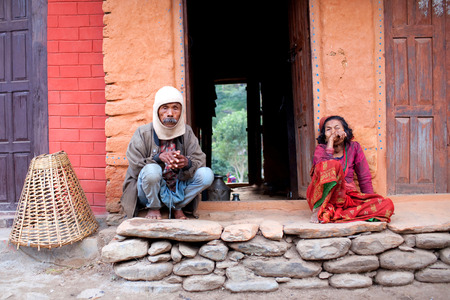 MANASLU AREA, NEPAL - NOVEMBER 15: Old Gorkhas man and woman on the doorstep of their home on November 15, 2009 in Arughat, Gorkha District, Nepal.のeditorial素材
