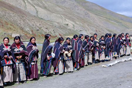 DHO TARAP, DOLPO, NEPAL - SEPTEMBER 11: Tibetan woman in national clothes waiting for Puja ceremony during Dho Tarap Full Moon Festival on September 11, 2011 in Dho Tarap village, Dolpo district, Nepalのeditorial素材