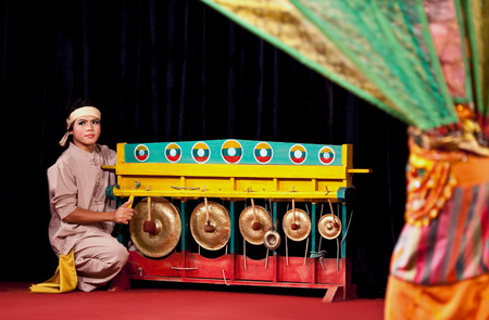 YANGON, MYANMAR - JANUARY 25: Burmese musician playing gongs on the evening show on January 25, 2011 in Yangon, Myanmarのeditorial素材