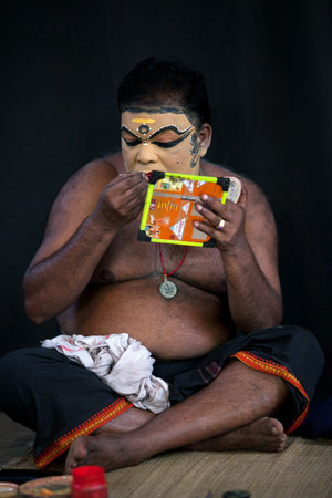 VARKALA, INDIA - FEBRUARY 10, 2010: Kathakali actor applies make-up before the evening performance in Varkala, India. Kathakali - the classical dance-drama of Kerala based on Indian mythology.のeditorial素材