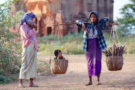 BAGAN, MYANMAR - JANUARY 8: Burmese women walking on the road to Myainkaba village on January 8, 2011 in Bagan, Myanmarのeditorial素材
