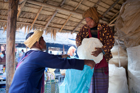 SAMKAR, MYANMAR - JANUARY 15: Pa-O tribal woman are selling local bread at the weekly market on...