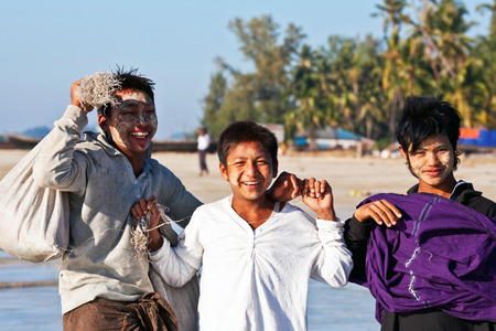 NGAPALI, RAKHAIN STATE, BURMA - JANUARY 23: Young smiling fishermen with thanaka paste on their faces poses for a photo on January 23, 2011 in Ngapali, Burmaのeditorial素材