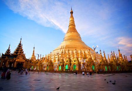 YANGON, MYANMAR - JANUARY 3, 2011: Pilgrims walking around golden Shwedagon Pagoda at sunrise in Yangon, Myanmar. The pagoda is situated on Singuttara Hill and dominates the Yangon skyline.のeditorial素材