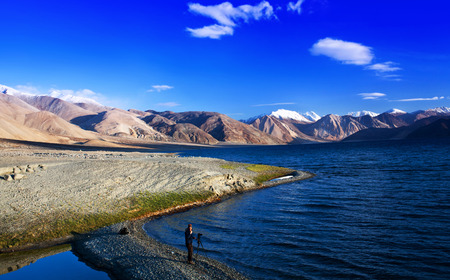 LADAKH, INDIA - JUNE 16, 2012: Photographer walking on Pangong Lake in Ladakh, Jammu and Kashmir State, Indiaのeditorial素材