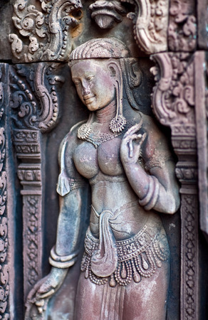 Apsara with lotus - ancient bas-relief at the facade of Banteay Srey Temple, Cambodia. Banteay Srey is a 10th century Cambodian temple.の写真素材