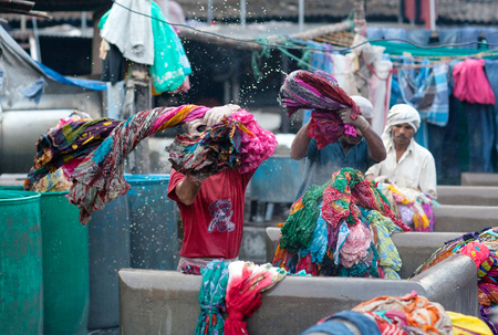 MUMBAI, INDIA - JANUARY 12, 2016: Indian workers washing clothes at Dhobi Ghat, a well know open air laundromat in downtown of Mumbai, Maharashtra Stateのeditorial素材