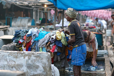 MUMBAI, INDIA - JANUARY 12, 2016: Indian workers washing clothes at Dhobi Ghat, a well know open air for clothes washing in downtown of Mumbai, Maharashtra Stateのeditorial素材