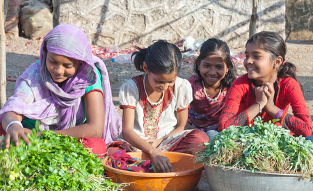 MAHARASHTRA, INDIA - JANUARY 10, 2016: Indian girls selling vegetables at local marketのeditorial素材