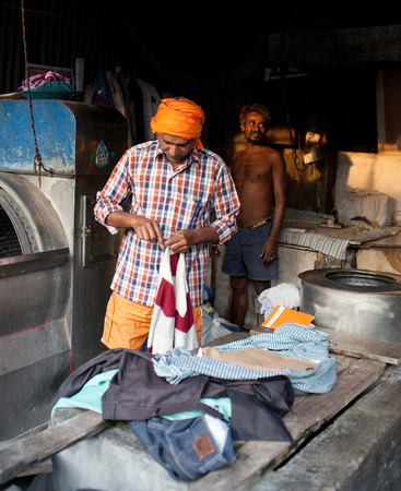MUMBAI, INDIA - JANUARY 12, 2016: Indian workers washing clothes at Dhobi Ghat, a well know open air laundromat in downtown of Mumbai in Maharashtra Stateのeditorial素材