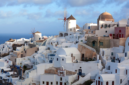 Panoramic view of Oia town at sunset, Santorini island, Cyclades, Greece. Traditional famous white houses, mills and churches over the Caldera in Aegean seaの写真素材