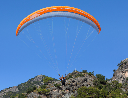 OLUDENIZ, TURKEY - NOVEMBER 5, 2017: Paraglider with tourist flying from Babadag mountain in Mugla provinceのeditorial素材
