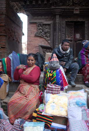 PATAN, NEPAL - JANUARY 22, 2017: Nepalese woman selling goods on the market at Durbar squareのeditorial素材