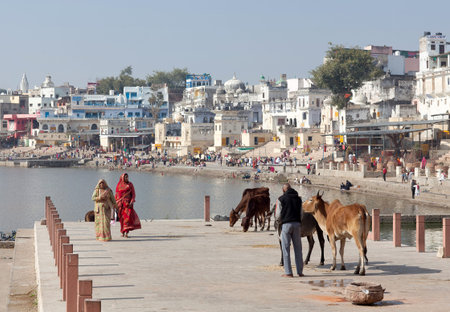 PUSHKAR, INDIA - JANUARY 5, 2019: Pilgrims walking on Ghat along Pushkar Sarovar lake. It is located...