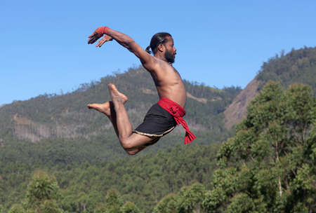 Indian fighter jumping up. Kalaripayattu Marital art demonstration in Kerala, South Indiaの写真素材