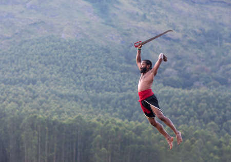Indian warrior fighter jumping up. Kalaripayattu Marital art demonstration in Kerala, South Indiaの写真素材